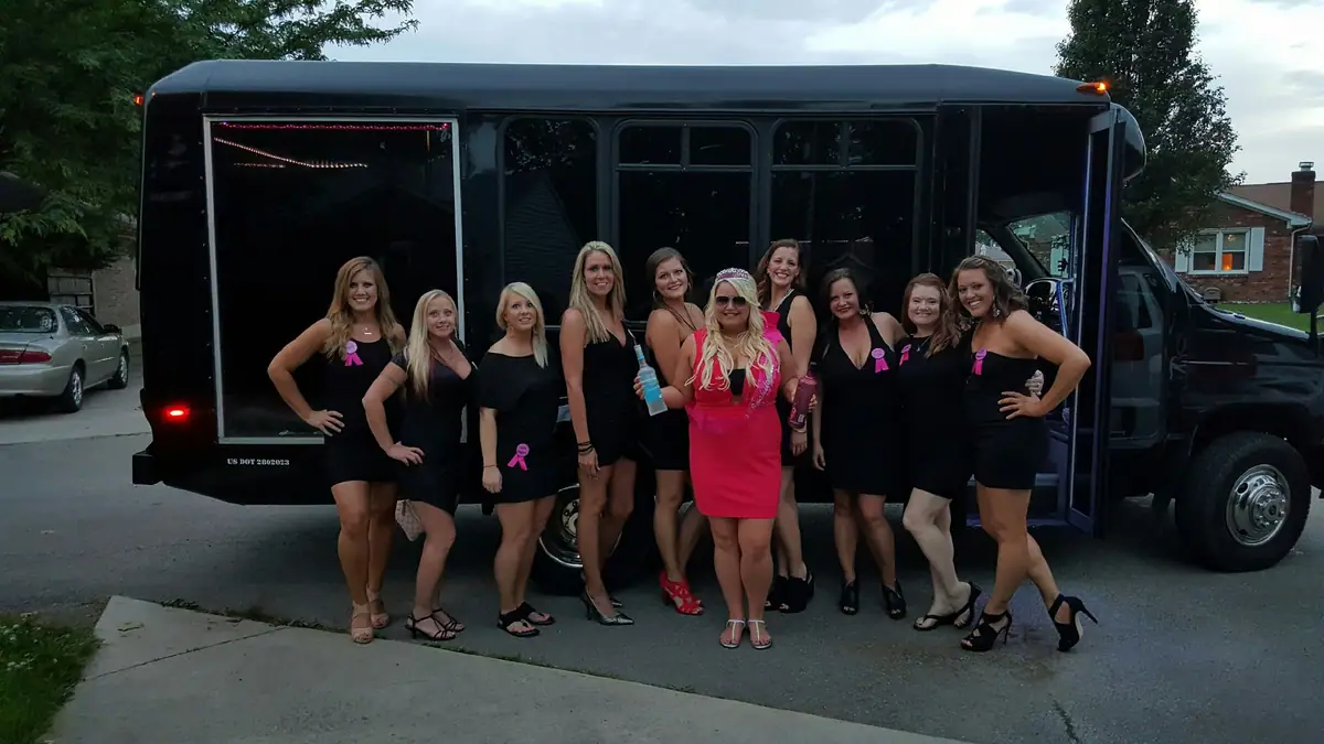 Group lined up in front of a black party bus
