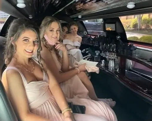 Bridesmaids seated inside a stretch limousine