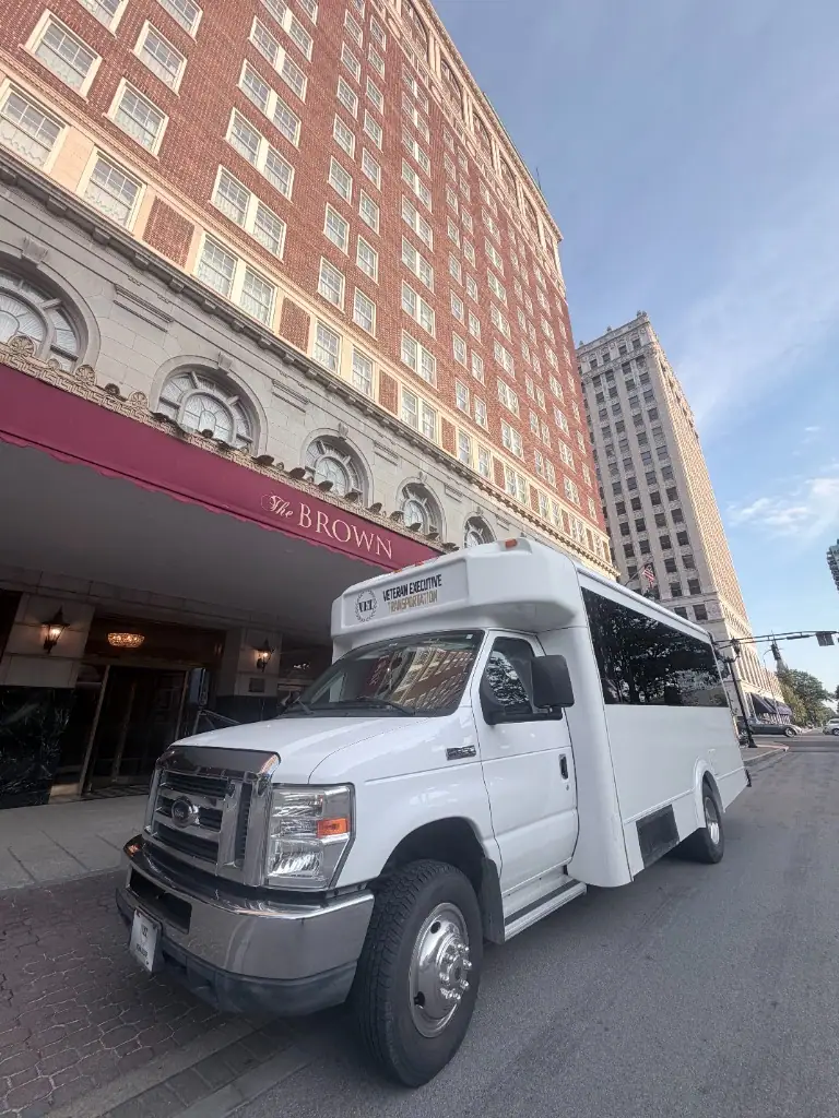 White VET shuttle bus parked at the Brown Hotel