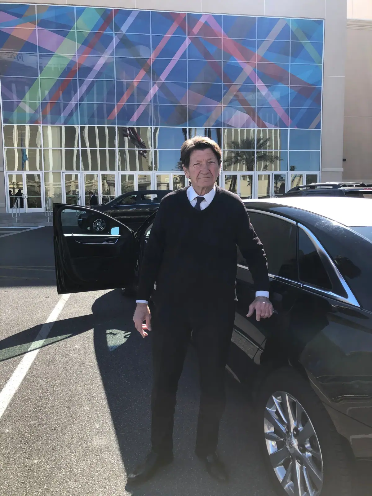 Chauffeur holding open the door of a black sedan