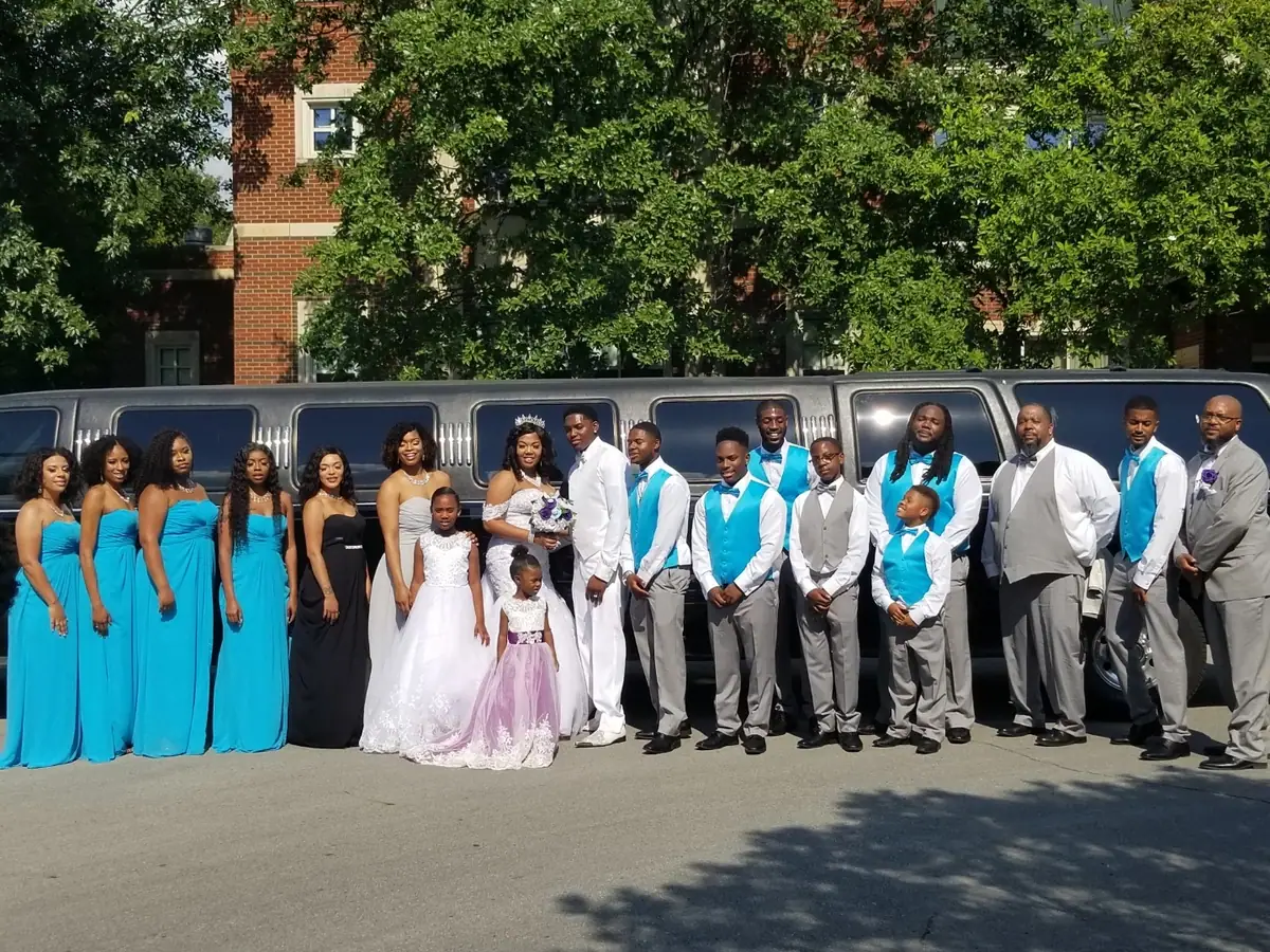 Wedding party beside a silver stretch limousine