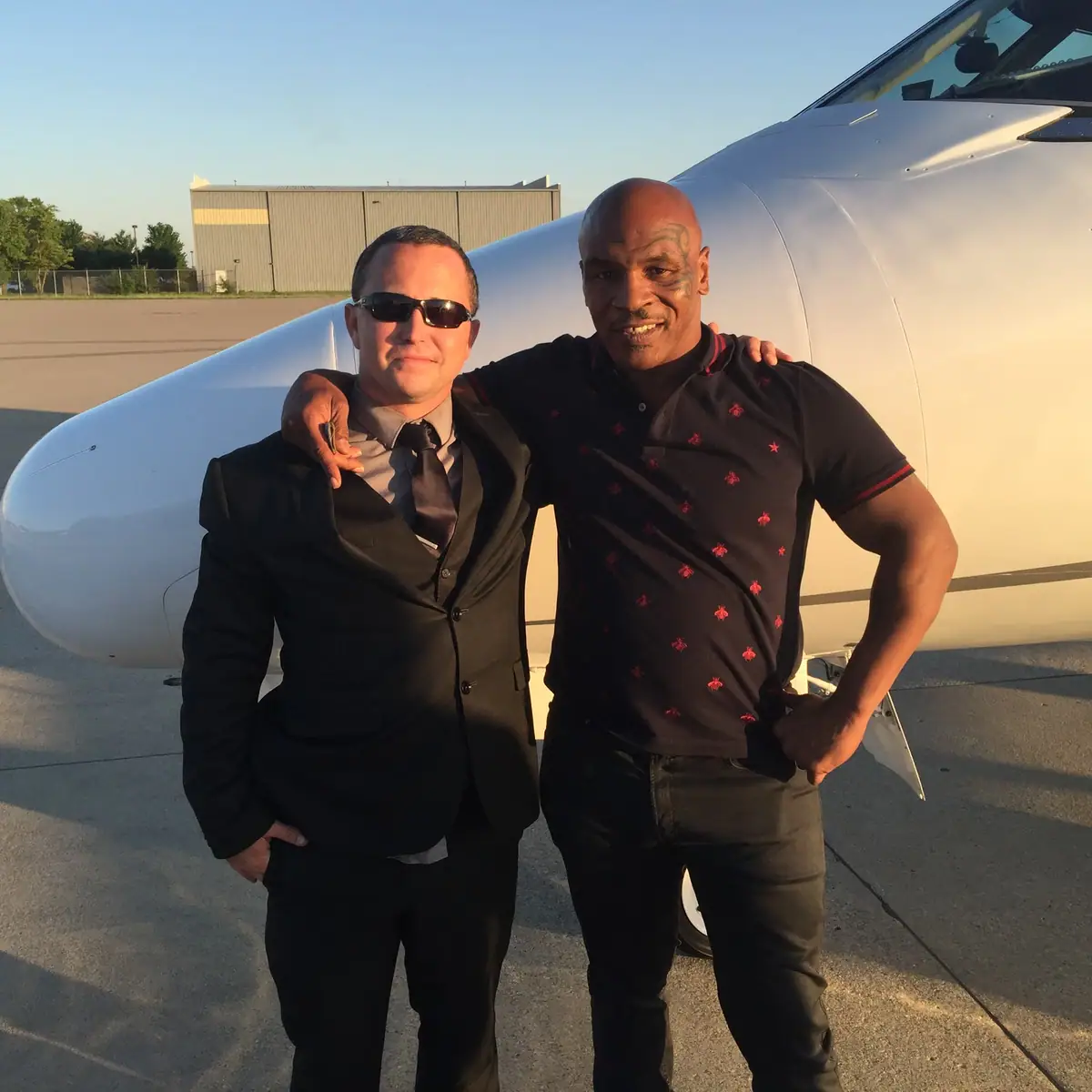 Veteran Executive Transportation chauffeur with Mike Tyson beside a private jet