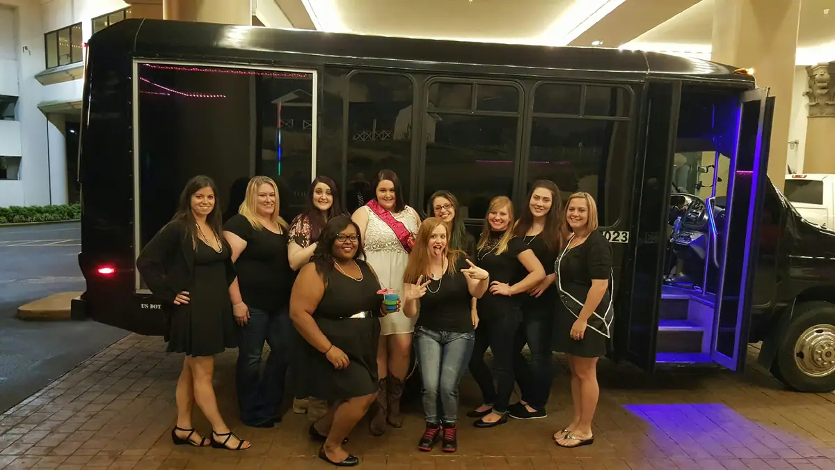 Group standing in front of a black party bus