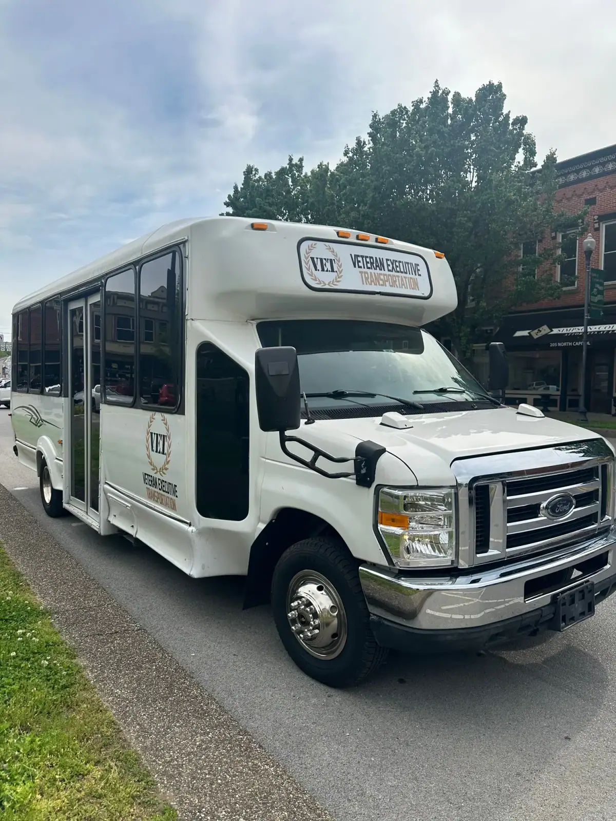 White VET shuttle bus parked on pavement