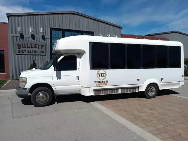 White VET shuttle bus outside the Bulleit distillery