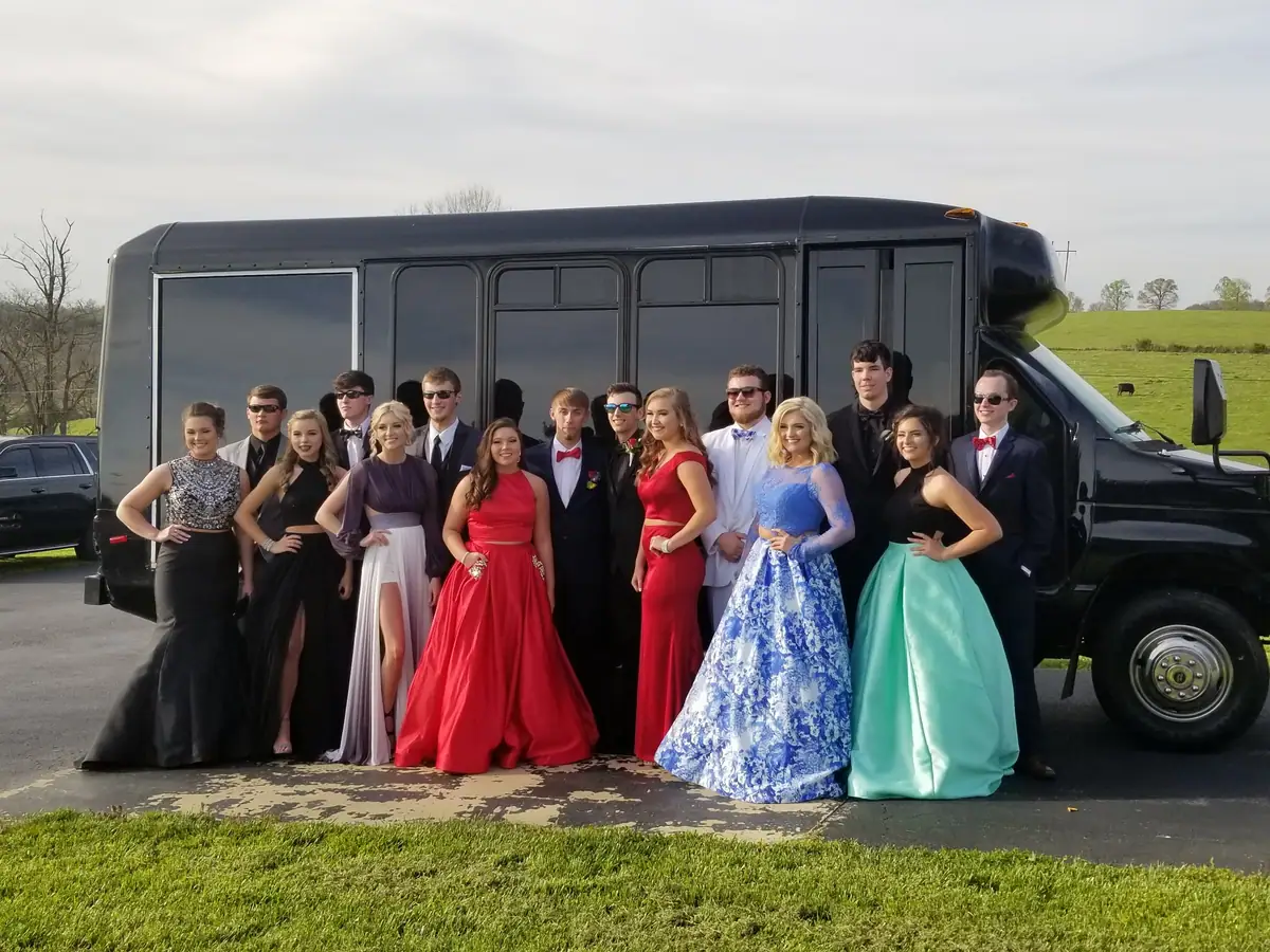 Prom group in front of a black party bus